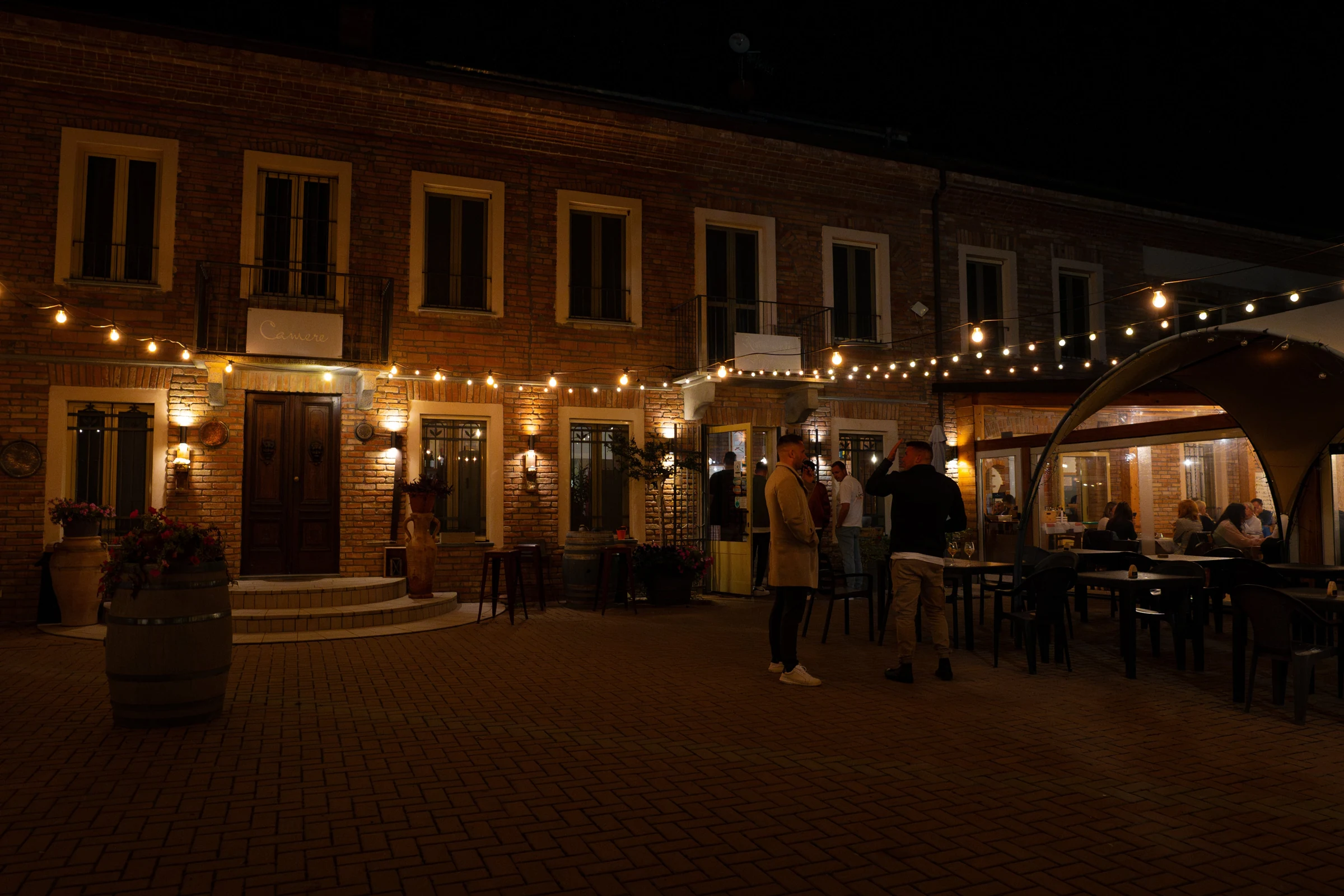 Innenhof mit warm beleuchteter Terrasse am Abend während Vino Sportivo 2024